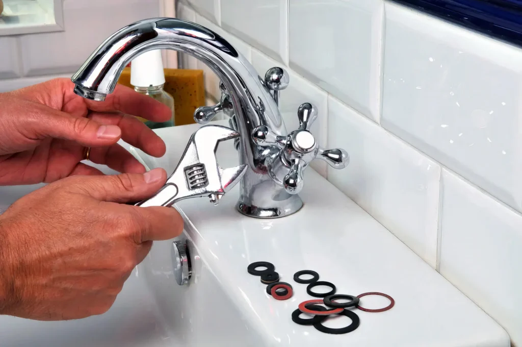 Plumber performing maintenance on a bathroom faucet in San Diego